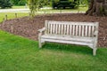 Wooden bench in lawn in a public park Royalty Free Stock Photo