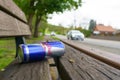 On a wooden bench lies an empty metal can of energy drink - Red Bull