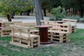 Wooden bench made of pallets for sitting with tables made from coil of electric cable Royalty Free Stock Photo