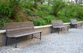 Wooden bench near the edge of the path in the park pedestrian blocks pavement retaining wall low metal frame benches elegant shape