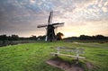 Wooden bench near windmill at sunrise Royalty Free Stock Photo