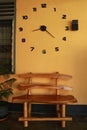 Wooden bench near yellow wall. Vintage wooden bench under the wall clock Royalty Free Stock Photo