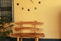 Wooden bench near yellow wall. Vintage wooden bench under the wall clock Royalty Free Stock Photo