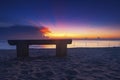 Wooden bench over beautiful tropical beach and magical twilight sunrise background