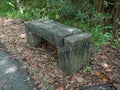 Wooden bench in the park,Behind a tall tree,Surrounded by dry leaves,At Sri Nakhon Khuean Khan Park and Botanical Garden in Bangko Royalty Free Stock Photo