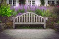 Wooden bench in a park sourrounded by flowers and lavender