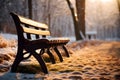 Wooden bench in the park in winter at sunset