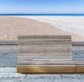 Wooden bench on public promenade with beach and sea background Royalty Free Stock Photo