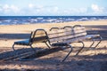 Wooden bench on sea beach with blue water background Royalty Free Stock Photo