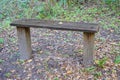A wooden bench sitting in the woods Royalty Free Stock Photo
