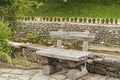 Wooden bench on stoned river bank Royalty Free Stock Photo