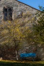 wooden bench under the autumn tree background of old walls Royalty Free Stock Photo