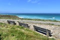 Wooden benches on a beach promenade with turquoise sea, waves and blue sky. Viveiro, Lugo, Galicia, Spain. Royalty Free Stock Photo