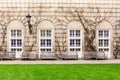 Wooden benches facing the wall with the arched stained-glass windows in the background Royalty Free Stock Photo