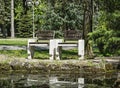 Wooden benches reflecting in water in the park