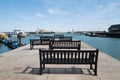 Wooden benches in the Royal Harbour, Ramsgate, looking out towards the lighthouse and an end of pier restaurant Royalty Free Stock Photo