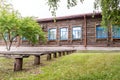 Wooden benches of a rural street theater in the open air, benches in front of an old public building made of logs Royalty Free Stock Photo