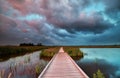 Wooden bike road on water at rainy sunset Royalty Free Stock Photo