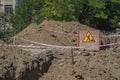 Wooden billboard with sign carrying out repair earthworks next to the dug trench Royalty Free Stock Photo