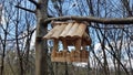 Wooden bird feeder made of wood in the style of houses from a log house. Decorative design of parks and recreation areas. Handmade Royalty Free Stock Photo