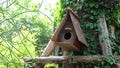 Wooden bird house hanging on the tree.