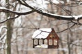 Wooden birdhouse for feeding birds under the snow on a tree branch. Winter time Royalty Free Stock Photo