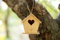 Wooden birdhouse hanging from tree in autumn garden. Concept for new home. A bird house or bird box in summer sunshine with natura Royalty Free Stock Photo