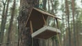 Wooden birdhouse hanging on tree in forest. Close-up of house for birds on branch of tree trunk.