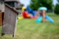 Wooden birdhouse mounted to a post in a backyard