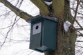wooden birdhouse ready for new spring season, cabin house against background of winter trees, concept of bird housewarming,