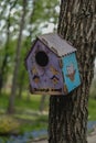 Wooden birdhouse on a tree. Hand crafted birdhouse design, nesting box among branch at spring Royalty Free Stock Photo