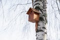 Wooden birdhouse on a tree in winter.