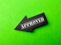 Wooden black arrow with the word APPROVED on a green background Royalty Free Stock Photo