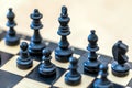 Wooden black chess pieces on a chessboard with a blurred background Royalty Free Stock Photo
