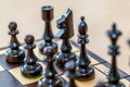 Wooden black chess pieces on a chessboard with a blurred background Royalty Free Stock Photo