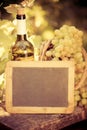 Wooden blackboard blank, wine bottle and grapes of vine Royalty Free Stock Photo