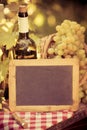 Wooden blackboard blank, wine bottle and grapes of vine Royalty Free Stock Photo
