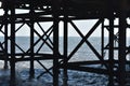 Wooden Blackpool Pier legs black on the Irish Sea water with blue sky Royalty Free Stock Photo