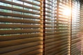 Wooden blinds in a home catching the sunlight with burst light