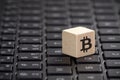Wooden block with bitcoin graphic on laptop keyboard