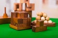 Wooden block brain teaser puzzle on green table in a blurred background Royalty Free Stock Photo