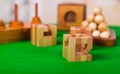 Wooden block brain teaser puzzle on green table in a blurred background Royalty Free Stock Photo