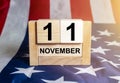 Wooden block calendar for November 11, USA Veterans Day, with Stars and Stripes usa flag on background Royalty Free Stock Photo