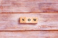 Wooden block cube for Now wording on white background. Concept of time management or living in present moment