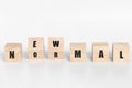 Wooden block cubes flipping new normal wording on white background