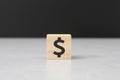 Wooden block dollar sign or peso sign on cement table black background wood cube concept