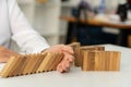 Wooden block domino`s hand stops falling. Risk concepts and strategies in business, the impact of continuous subversion and preven