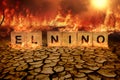 Wooden block of El Nino on cracked mud and wild fire background. climate change and global warming concept