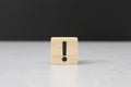 Wooden block in exclamation mark on cement table black background wood cube concept mean not entirely lost all sense