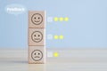Wooden block for satisfaction survey with star and negative, neutral and positive facial expressions. Royalty Free Stock Photo